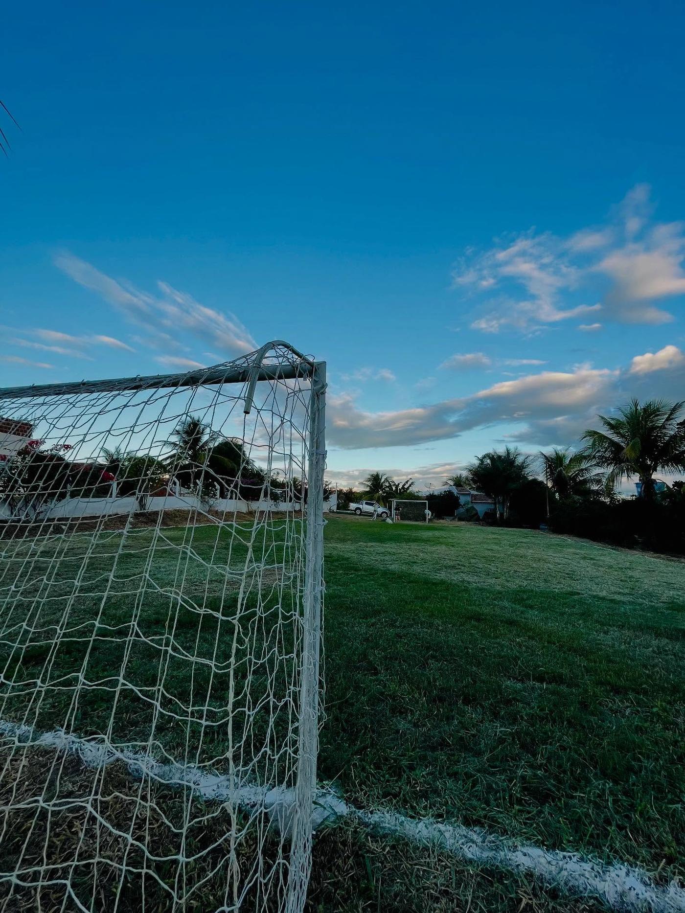 Trave do campo de futebol ao entardecer